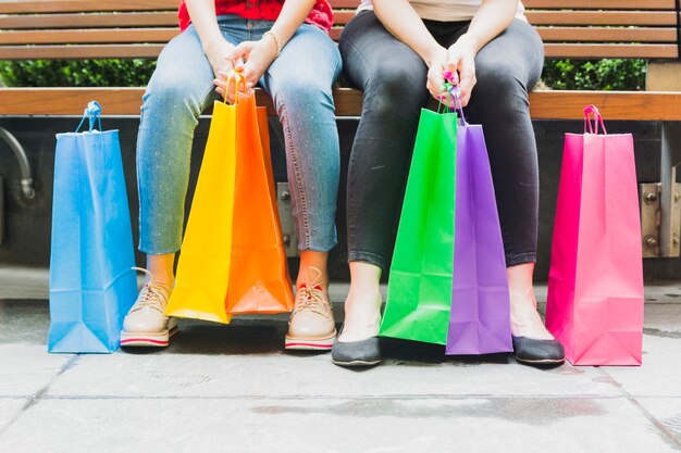 Femmes assises sur un banc avec des sacs à provisions