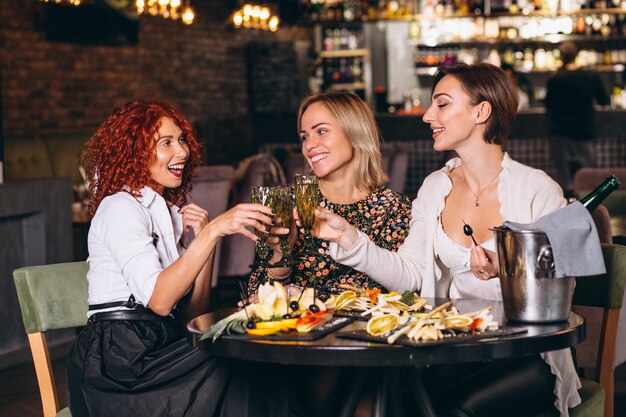 Femmes au bar discutant de cocktails