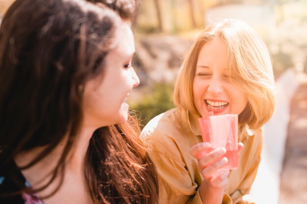 Femmes avec des boissons qui rient