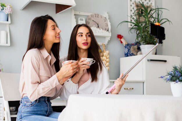 Femmes buvant du café et prenant selfie