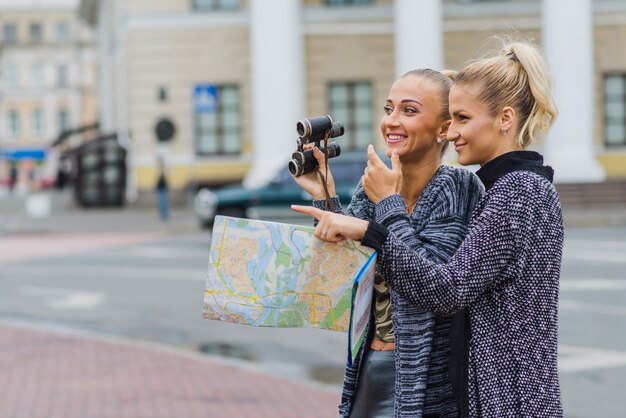 Femmes avec carte et jumelles ensemble