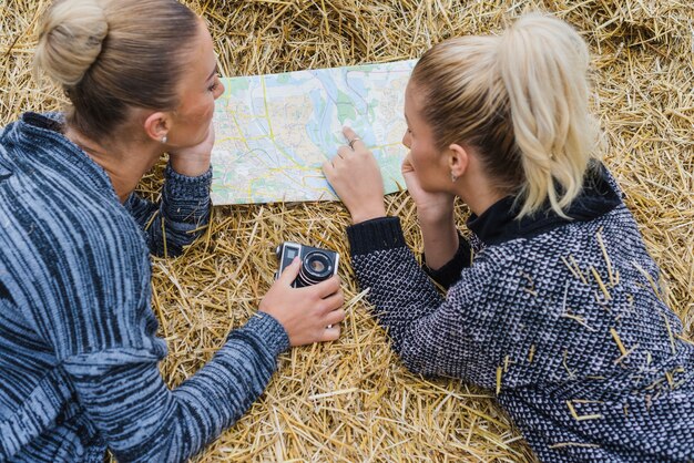 Femmes couché avec la carte dans le foin