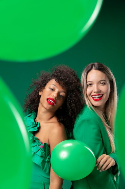 Femmes de coup moyen avec des ballons verts