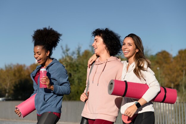 Femmes de coup moyen avec des tapis de yoga