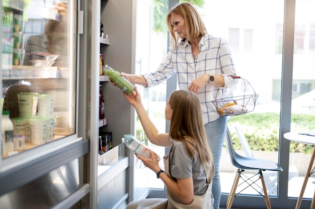 Femmes de coup moyen vérifiant des produits