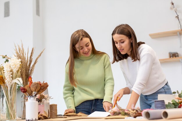 Les femmes dans leur magasin de fleurs se concentrant