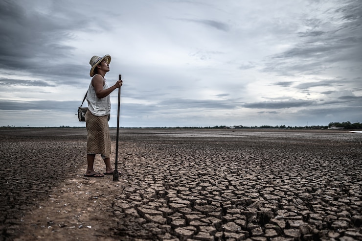 Photo gratuit femmes debout sur un sol sec et des engins de pêche, réchauffement de la planète et crise de l'eau