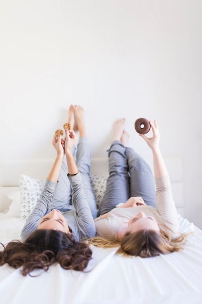 Femmes avec des desserts sur le lit