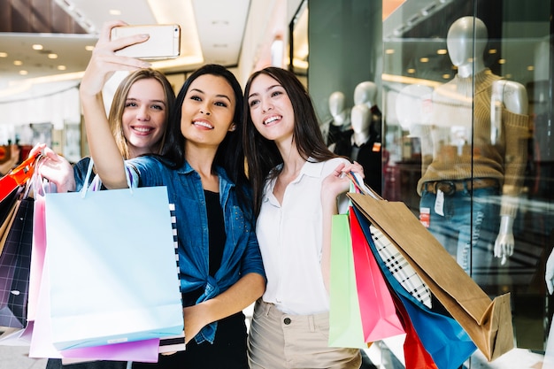 Femmes élégantes prenant selfie dans le centre commercial