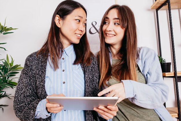 Femmes excitées joyeuses avec tablette