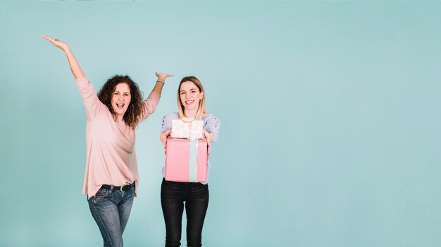 Femmes excitées montrant des cadeaux à la caméra