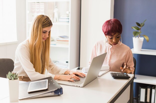 Femmes faisant des calculs au bureau