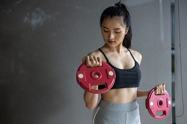 Femmes faisant de l'exercice avec deux disques d'haltères