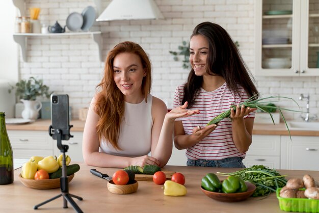 Femmes faisant un vlog tout en préparant la nourriture