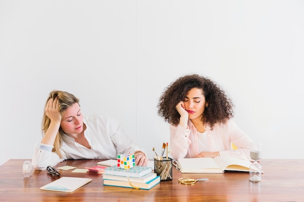 Femmes fatiguées, assis à une table