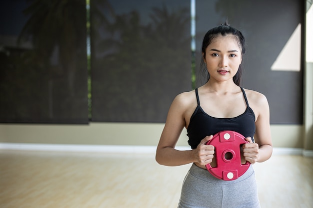 Les femmes font de l'exercice avec des disques d'haltères dans la poitrine.