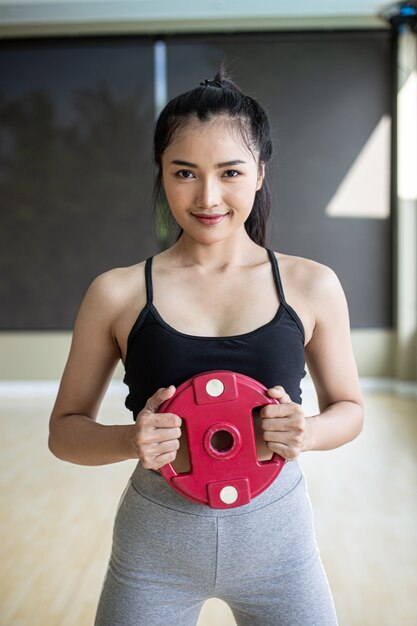 Les femmes font de l'exercice avec des disques d'haltères dans la poitrine.