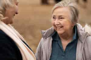 Photo gratuite femmes heureuses bavardant à l'extérieur