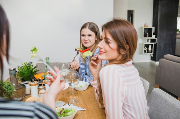 Femmes heureuses dans des chemises mangeant