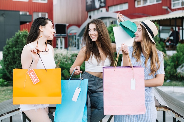 Les femmes heureuses discutent après le shopping