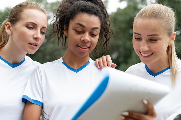 Photo gratuite femmes heureuses avec presse-papiers