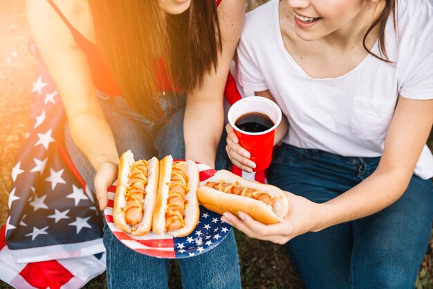 Femmes avec des hot-dogs et des boissons