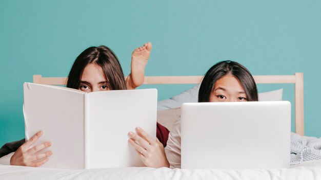 Femmes avec livre et ordinateur portable