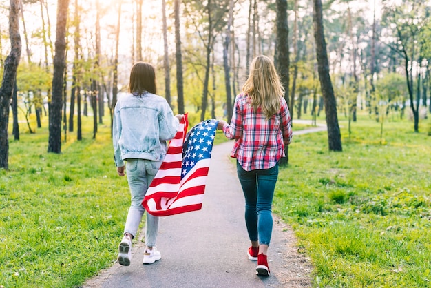 Femmes marchant dans le parc avec drapeau USA