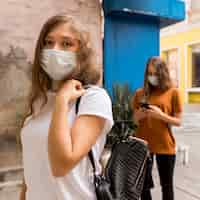 Photo gratuite femmes avec des masques médicaux dans la file d'attente à l'extérieur