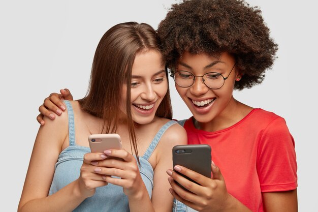 Des femmes métisses satisfaites discutent de l'application mobile