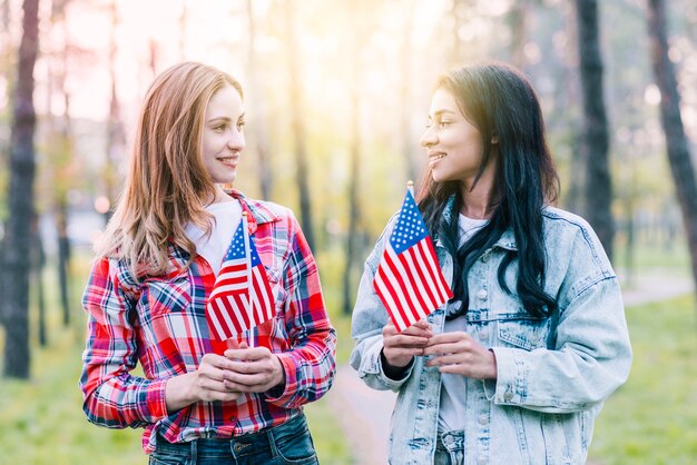 Femmes avec petits drapeaux américains debout à l&#39;extérieur