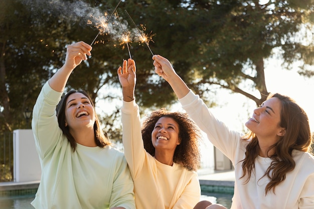 Femmes plan moyen avec feux d'artifice