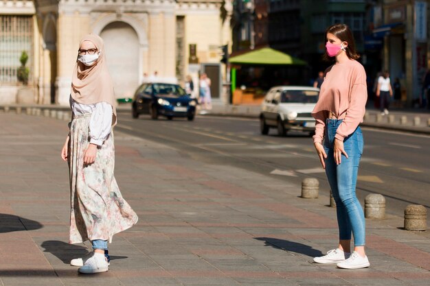 Femmes à pleine longueur gardant la distance sociale