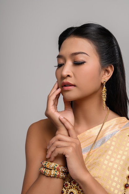 Femmes portant des vêtements thaïlandais et leurs mains touchant leur visage