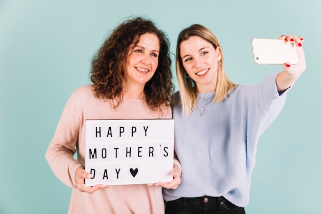 Femmes prenant selfie avec voeux de fête des mères