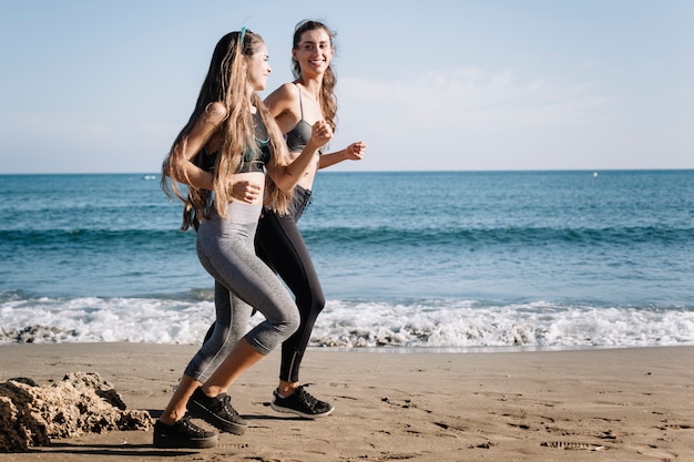 Femmes qui font du jogging à la plage