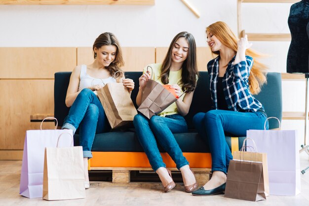 Femmes regardant des vêtements sur le canapé