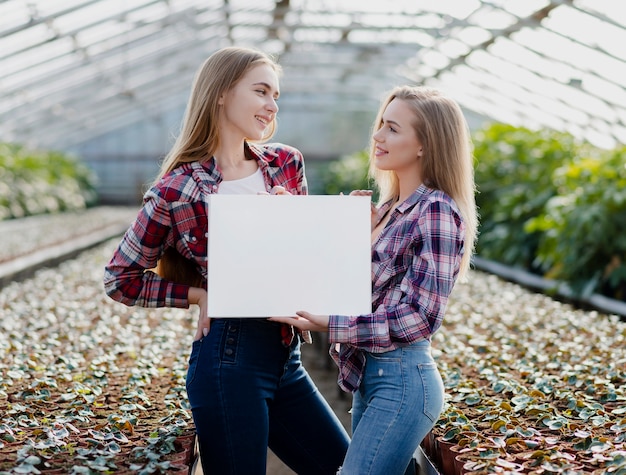 Femmes en serre tenant une feuille vierge