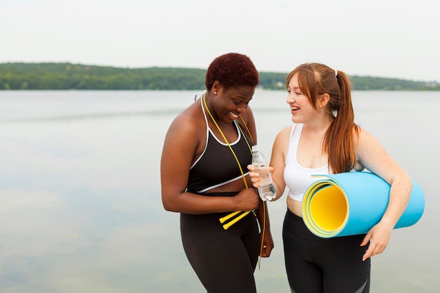 Femmes Smiley profitant de leur temps ensemble tout en faisant de l'exercice