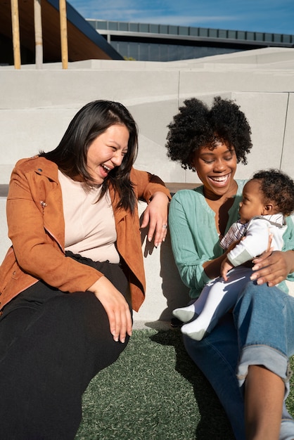 Photo gratuite femmes souriantes et bébé mignon à l'extérieur