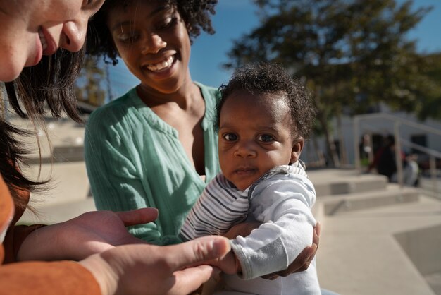 Femmes souriantes et bébé mignon à l'extérieur