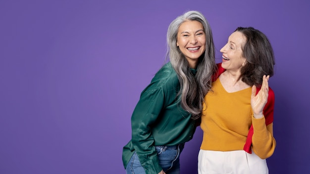 Femmes souriantes à coup moyen avec fond violet