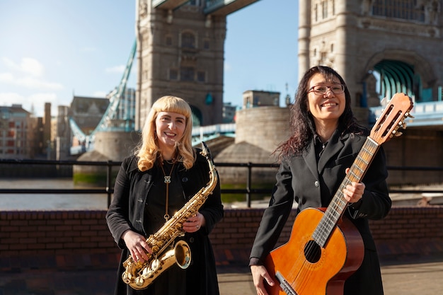 Photo gratuite femmes souriantes à coup moyen avec des instruments