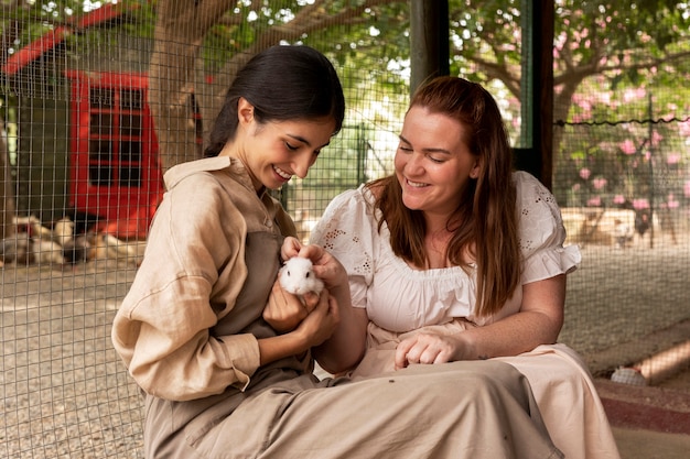 Photo gratuite femmes souriantes à coup moyen avec un lapin mignon