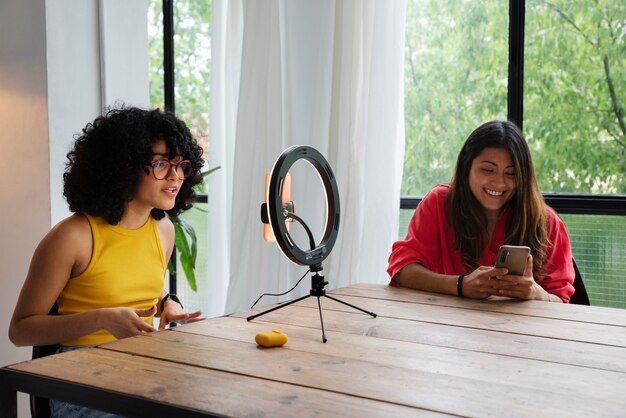 Femmes souriantes à coup moyen avec technologie