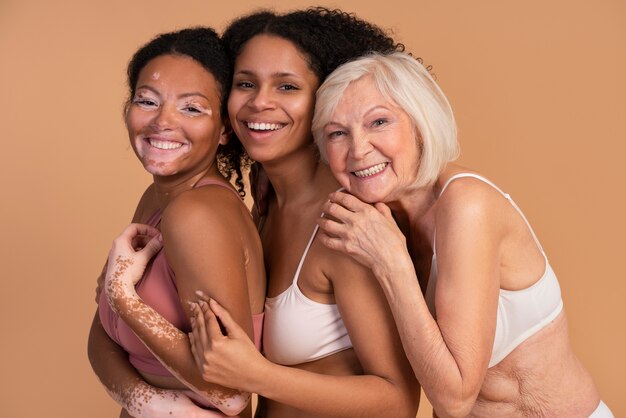 Femmes souriantes de plan moyen posant ensemble