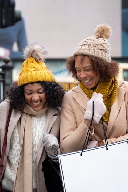 Photo gratuite femmes souriantes de plan moyen avec des sacs à provisions