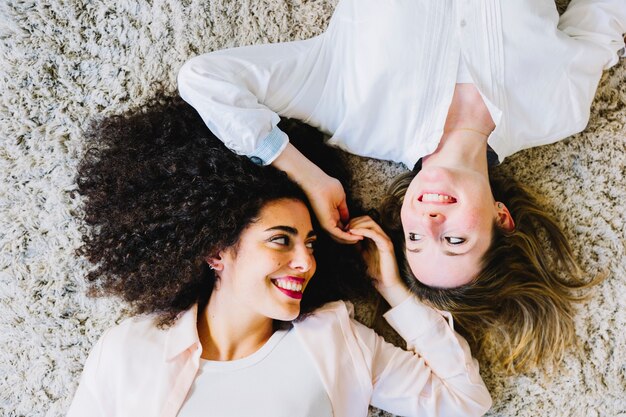 Femmes souriantes sur le tapis en se regardant