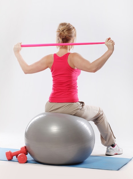 Femmes sportives faisant des exercices d'étirement avec ballon de stabilité fitness