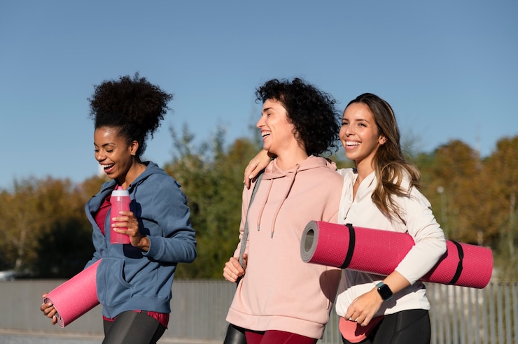Photo gratuit des femmes de taille moyenne avec des tapis de yoga.